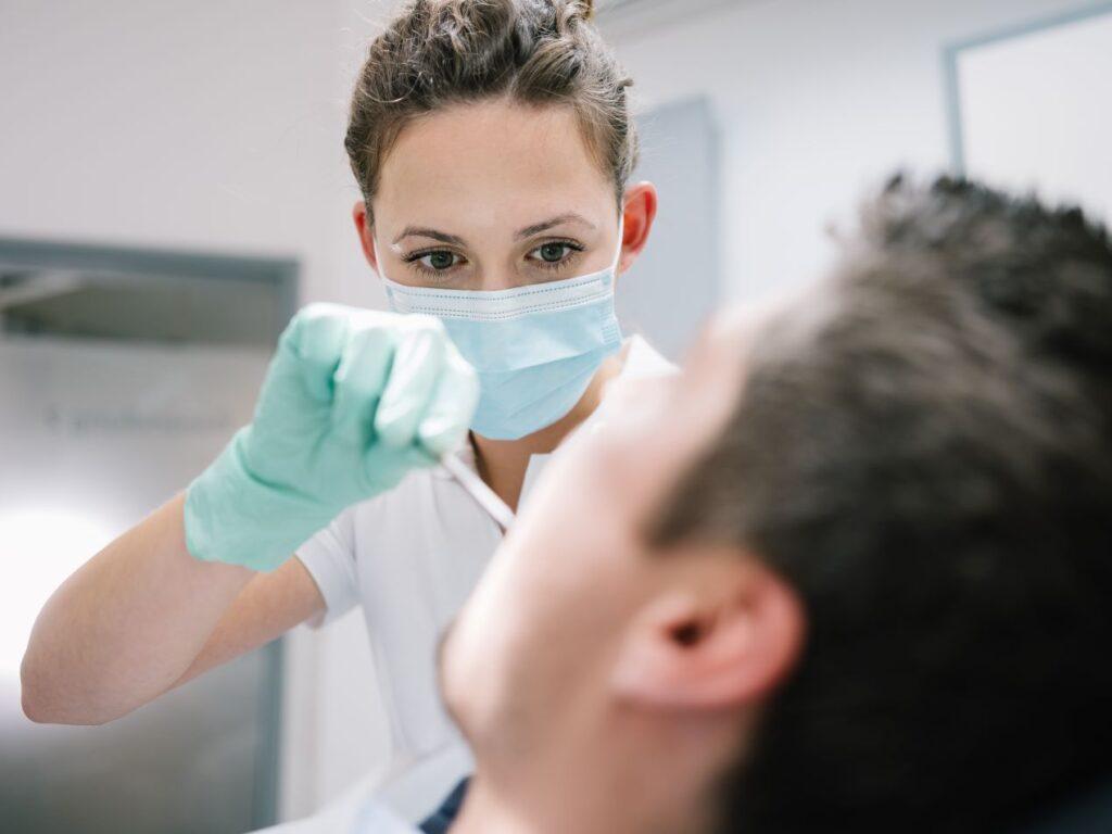 Zahnärztin in Essen führt professionelle Parodontitis-Untersuchung bei einem Patienten durch, mit Fokus auf Zahnfleischgesundheit und Prävention