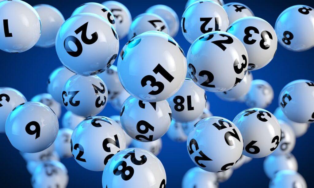 Eine Vielzahl von schwebenden Lottokugeln mit Zahlen, die auf die Ziehung im Eurojackpot online spielen hinweisen.