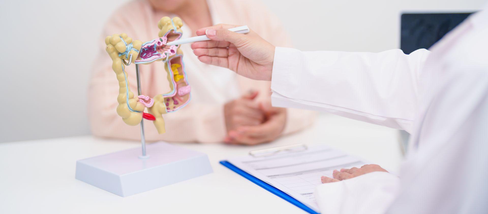 Patientin mit Bauchbeschwerden beim Arzt Beispiel fuer Verdauungsprobleme die durch CURCUMA KAPSELN gelindert werden koennen