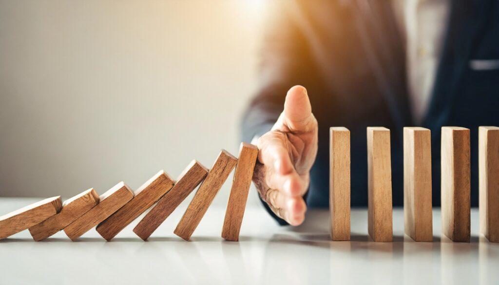 Hand stoppt fallende Dominosteine | Scheidung Kosten