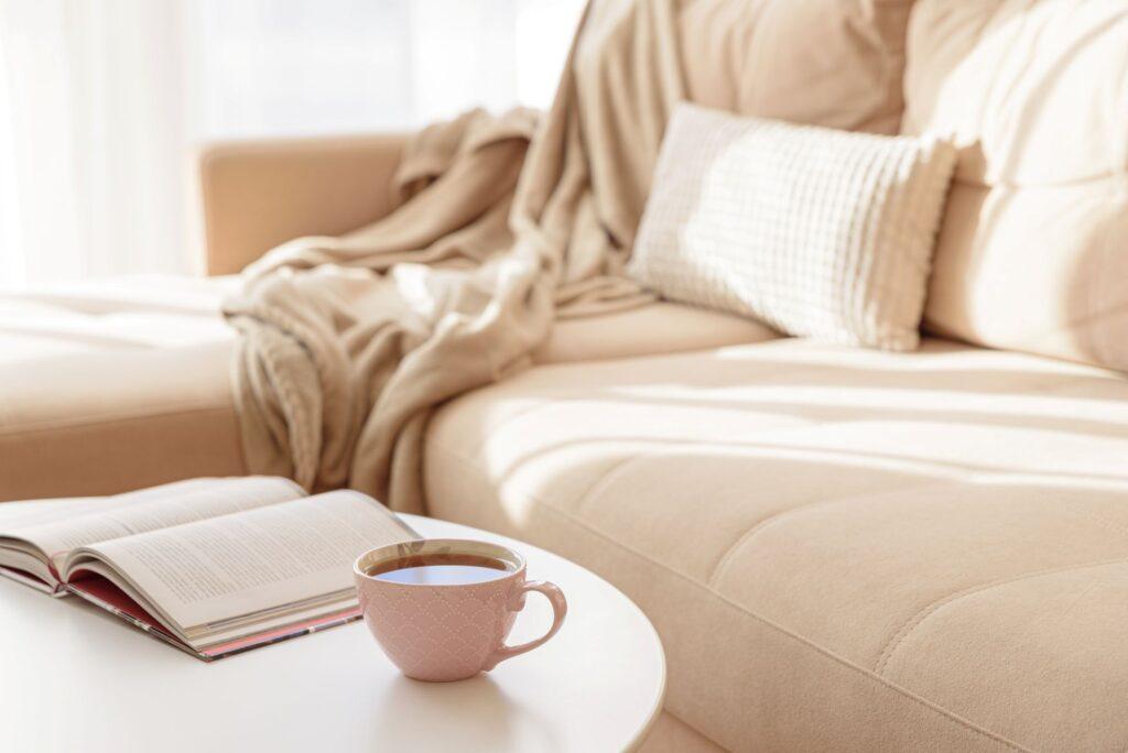 Gemuetlicher Wohnbereich mit Decke, Sofa und Tee – ideales Raumklima durch Elektrotherme