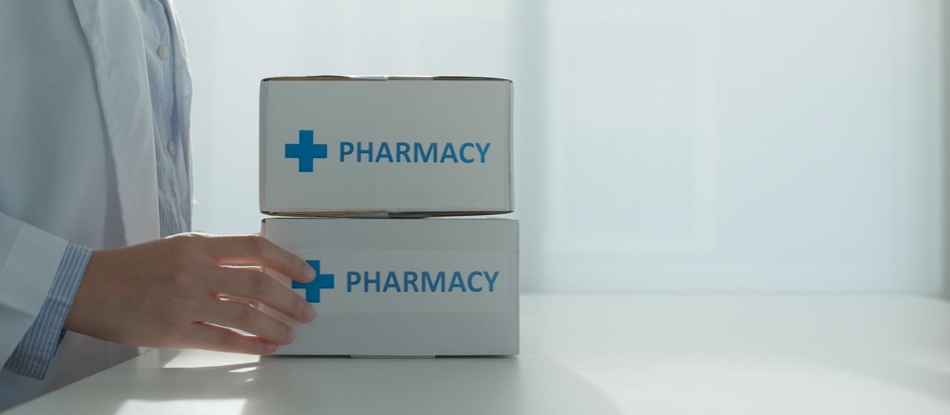 Person transportiert zwei Kartons mit der Aufschrift PHARMACY | Marketingübersetzung